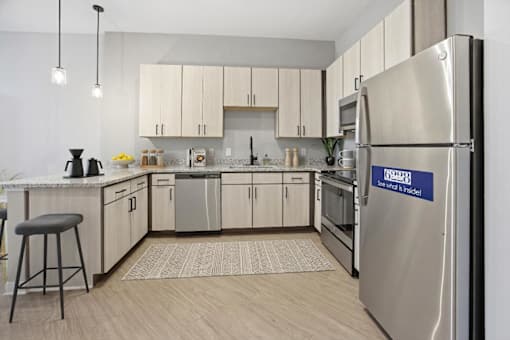A kitchen with a stainless steel refrigerator that says "Sense of Style".