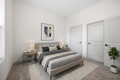 A bedroom with a large bed, a potted plant, and a framed picture on the wall.