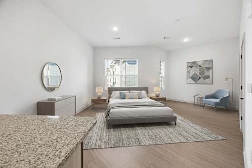 A bedroom with a large bed and a blue chair.