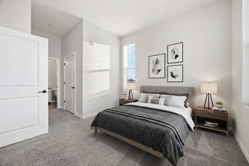 A bedroom with a large bed and a nightstand with a lamp.