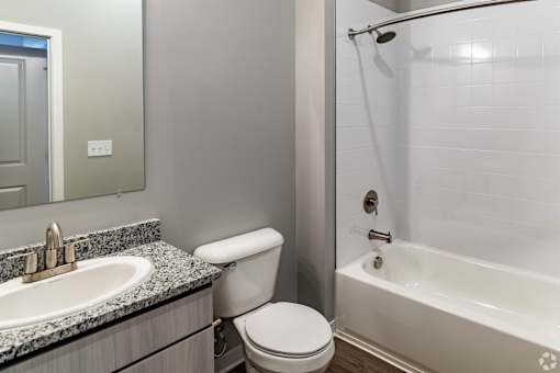 A white toilet sits next to a sink in a bathroom.