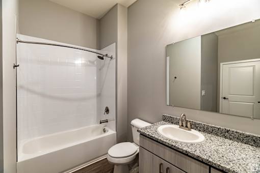 A white bathroom with a sink, toilet and bathtub.