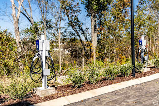 A charging station for electric vehicles is located in a landscaped area.
