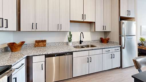 A kitchen with white cabinets and a stainless steel dishwasher.