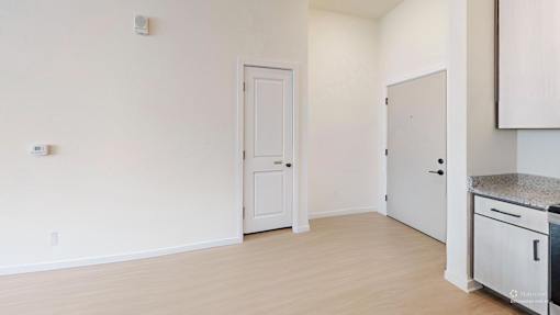 A kitchen area with a white door and a white cabinet.