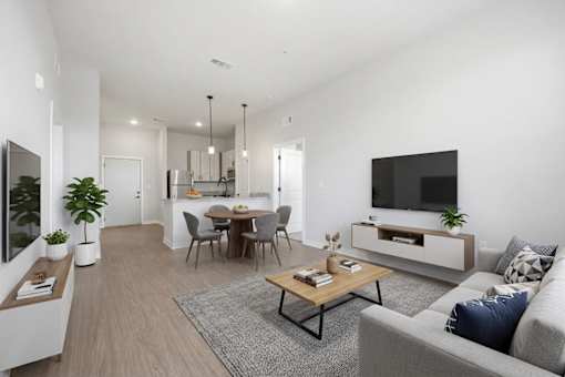 A modern living room with a grey sofa, a wooden coffee table, and a television.