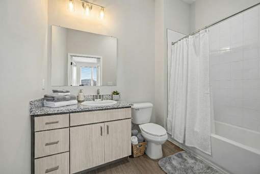 A bathroom with a toilet, sink, and shower.