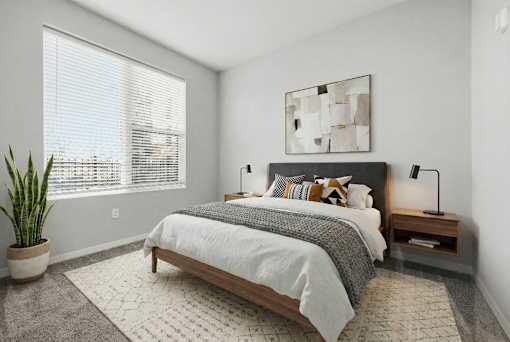A bedroom with a large bed, a potted plant, and a painting on the wall.