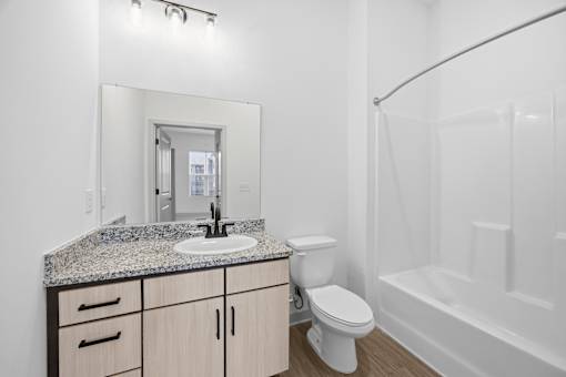 A white bathroom with a sink, toilet, and bathtub.