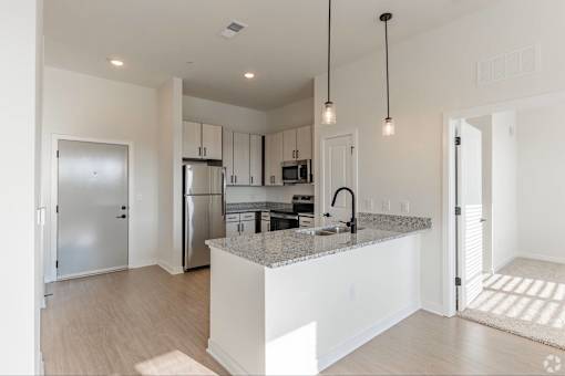 A modern kitchen with a granite countertop and stainless steel appliances.