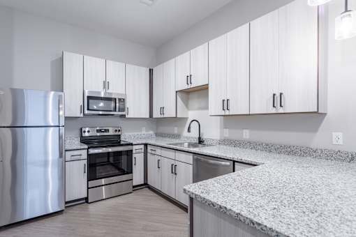 A kitchen with white cabinets and stainless steel appliances.