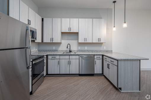 A modern kitchen with stainless steel appliances and wooden cabinets.