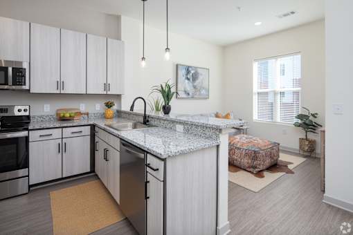 A kitchen with a granite countertop and stainless steel appliances.