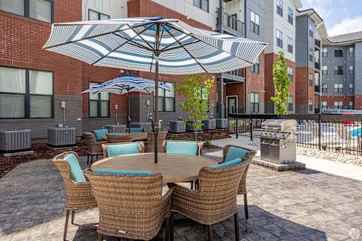 A patio with a table and chairs under an umbrella.