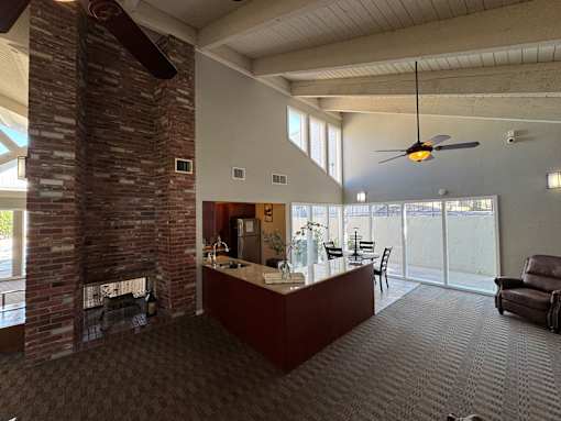 A kitchen area with dining table sits next to a fireplace.