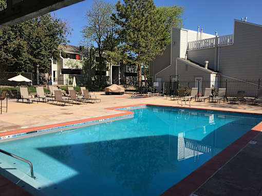 A swimming pool with pool chairs.