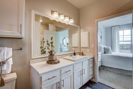 A bathroom with a white vanity and a large mirror.