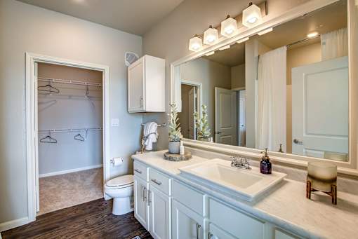 A bathroom with a toilet, sink, and mirror.