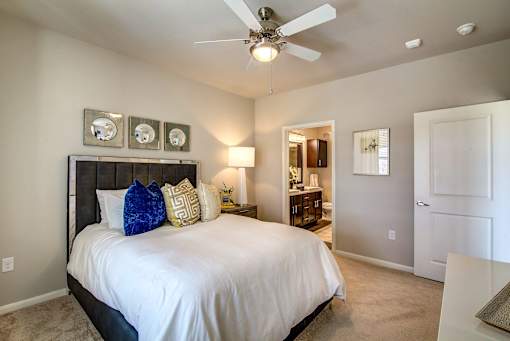 A bedroom with a bed, nightstands, and a ceiling fan.