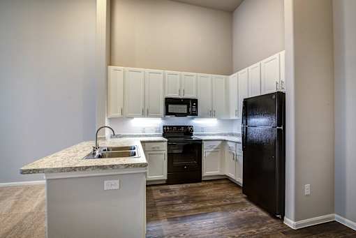 A kitchen with a granite countertop and white cabinets.