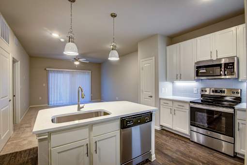 A kitchen with white cabinets and stainless steel appliances.