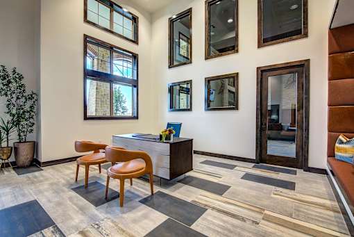 A room with a desk, chair, and pictures on the wall.
