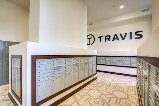 A Travis sign is on the wall above a row of lockers.