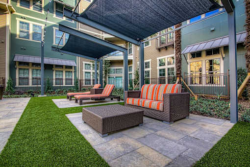 A patio with a couch and a table under a canopy.