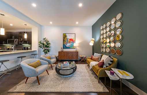 A modern living room with a grey sofa, yellow armchair, and a coffee table.