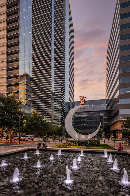 A fountain in the foreground with a large building in the background.