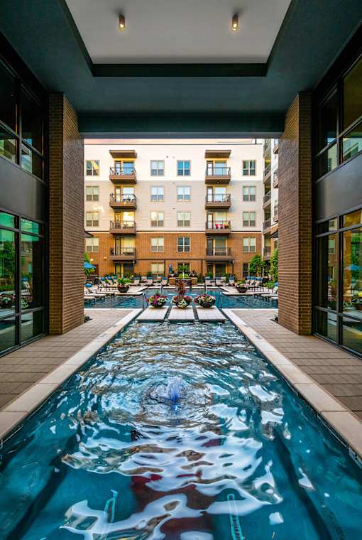 A long rectangular pool with a fountain in the middle.