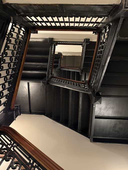 A staircase with a mirror on the side.