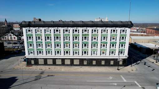 A large white building with green trim and a black roof.