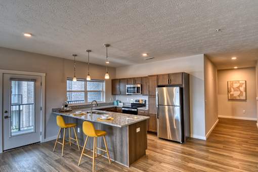 A modern kitchen with a large island and stainless steel appliances.