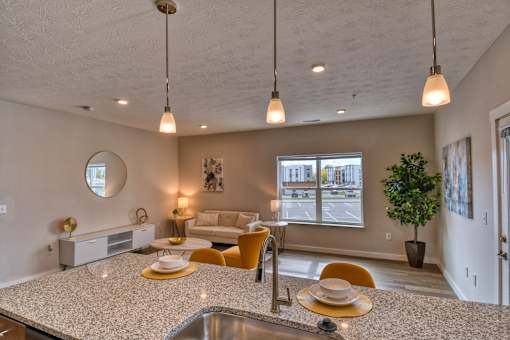 A modern kitchen with a large island and pendant lights.