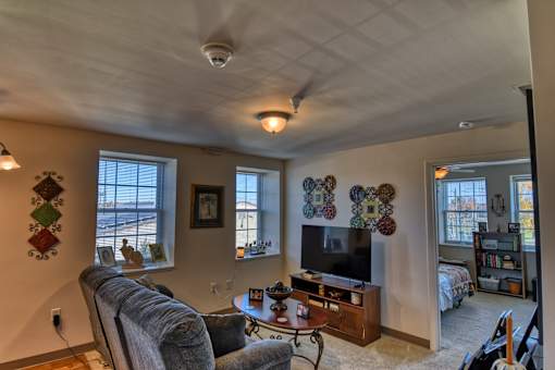 A living room with a grey couch, a wooden coffee table, and a television.
