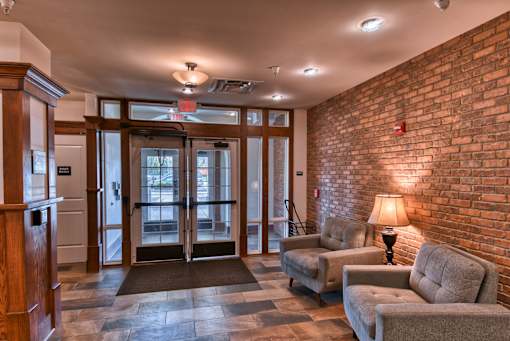 A room with a brick wall and a glass door.