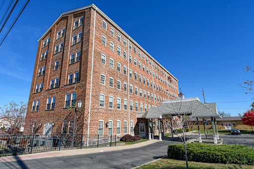 A large red brick building with a black fence in front.
