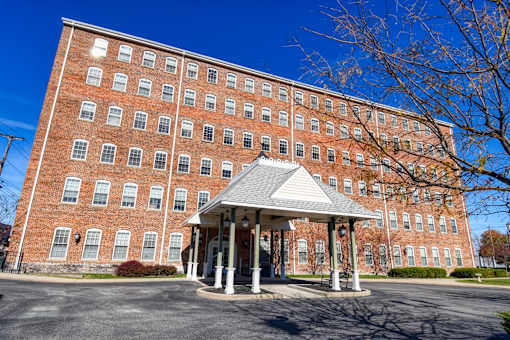 A large red brick building with a white covered walkway in front.