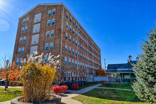 A large brick building with a green lawn in front.