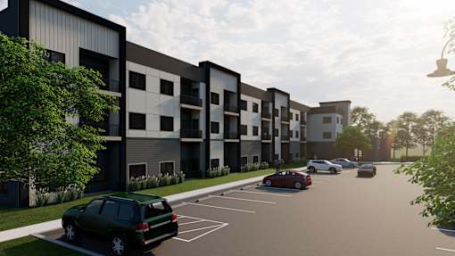 A modern apartment complex with a parking lot in front.