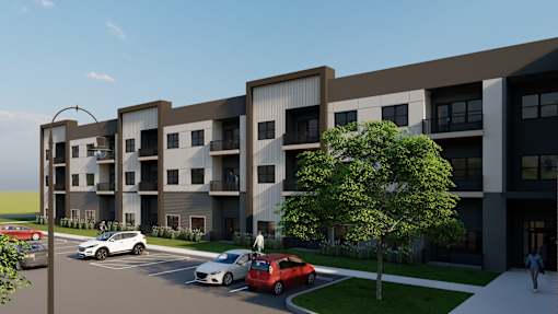 A modern apartment complex with cars parked in front.
