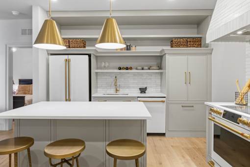 A modern kitchen with a white and gold color scheme.