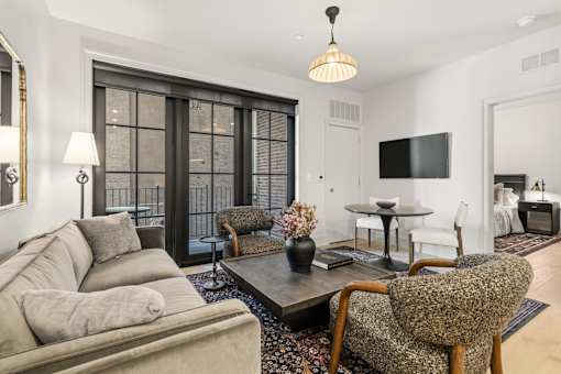 A living room with a grey couch, a brown chair, and a black table.