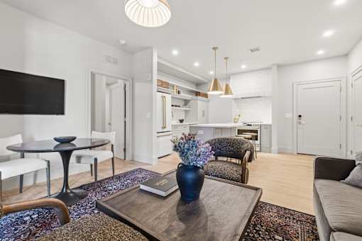 A modern living room with a black coffee table and a blue vase on it.
