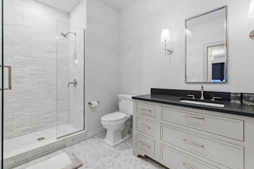 A white toilet sits next to a sink in a bathroom.