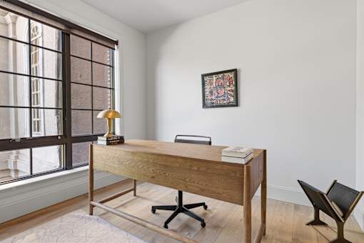A wooden desk with a lamp and a book on it.