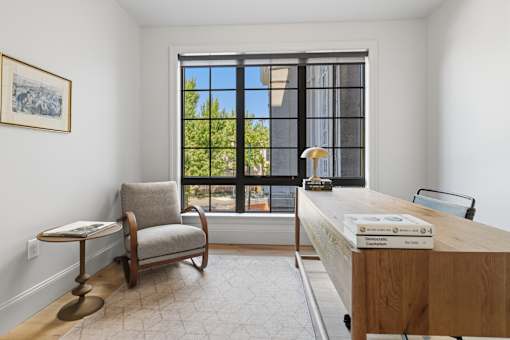 A room with a chair, a table, and a window.