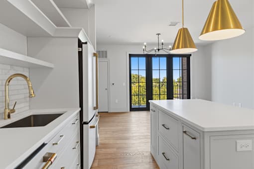 A kitchen with white cabinets and a black fridge.