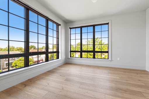 A room with a large window and wooden flooring.